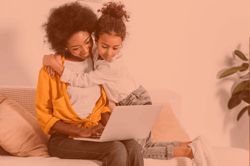A young Black woman with her child sitting on a sofa with her laptop on her lap learning how askBetty helps you tackle your to-do list in Slack.