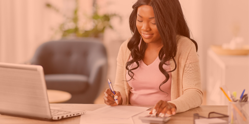 Une jeune femme noire, assistante virtuelle en comptabilité chez Virtual Gurus, assise à son bureau à domicile.