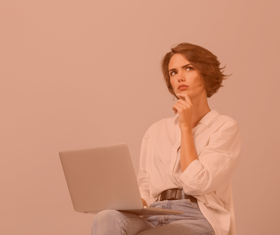 woman sitting in front of her computer looking up and thinking