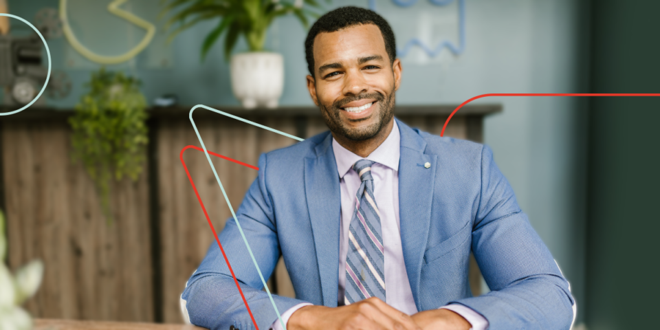 Homme noir souriant, assistant virtuel en comptabilité, aimant travailler depuis son bureau à domicile.