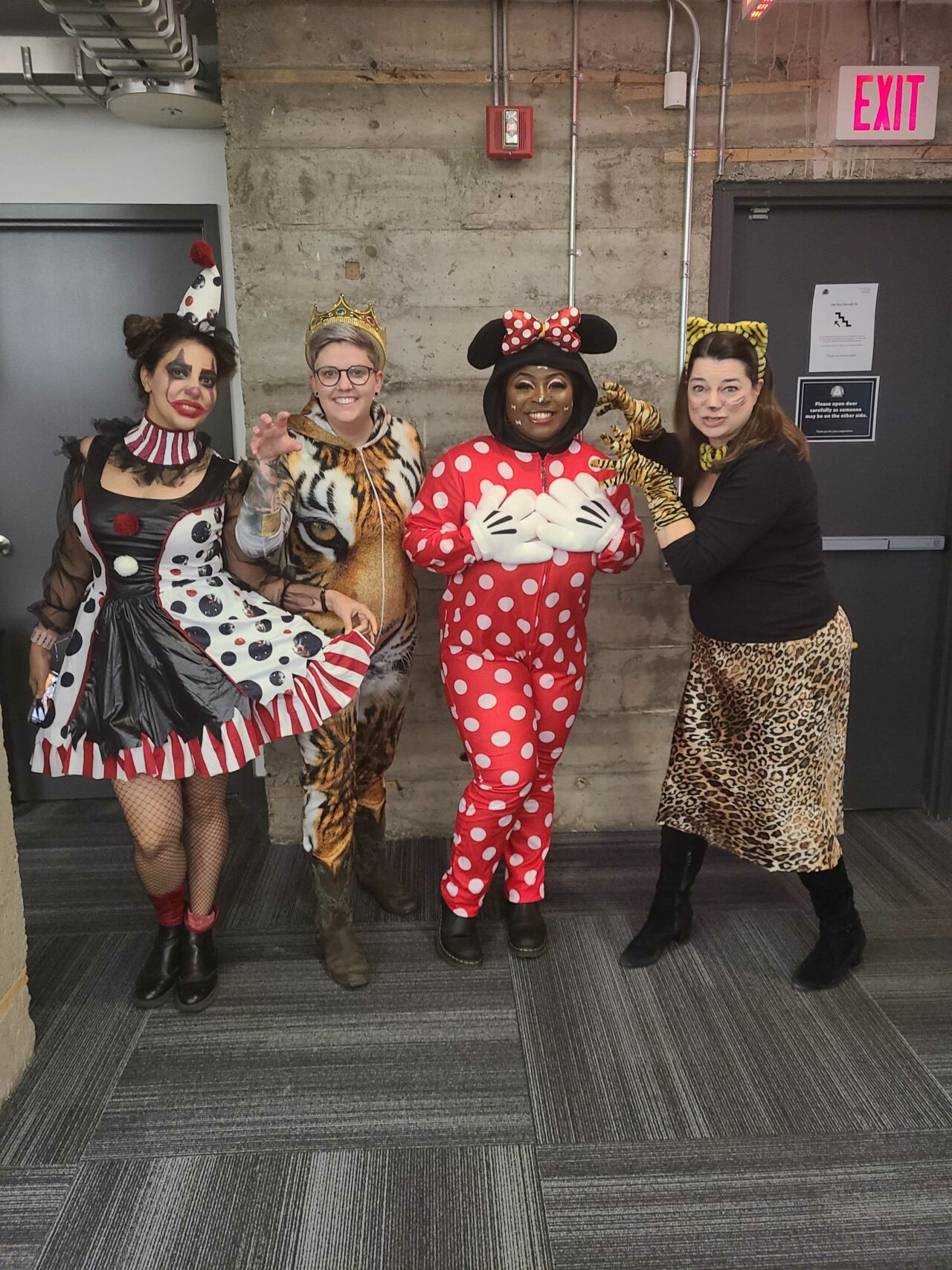 Four female Virtual Gurus staff members dressed up for Halloween one as a clown, one as a royal tiger, one as Minnie Mouse, and the other as a leopard.