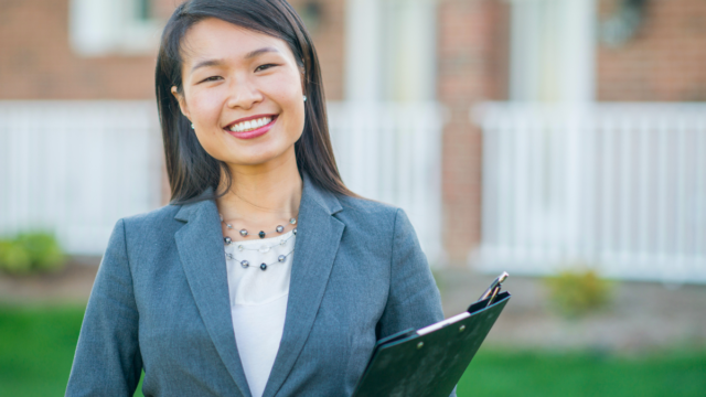 Asian woman, Realtor, holding her clipboard and smiling because she has the freelancer advantage with her real estate assistant.